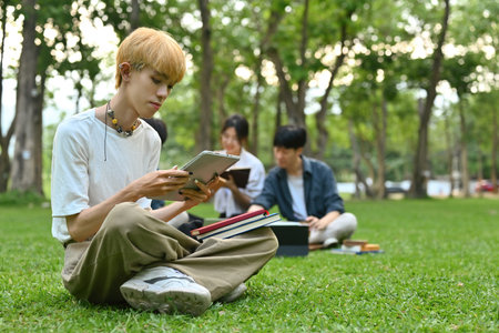 Portrait of an LGBT Asian male university student and a group of friends doing group work on the...