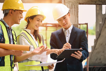 Inspector and workers discuss construction plans, illuminated by sunlight, creating a positive and...