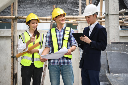 The general project manager checks the progress of the work and visits with workers at construction sites.の写真素材