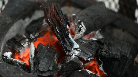 Close-up of glowing hot charcoal embers, ready to provide consistent heat for grilling, creating the perfect environment for cooking.の写真素材