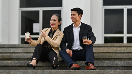 Casual Conversations, Bonding Over Coffee on the Steps Between A senior professional woman and a...