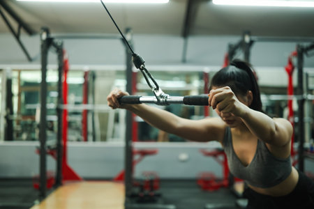 Close-up of Woman Performing Cable Straight Arm Pulldown.