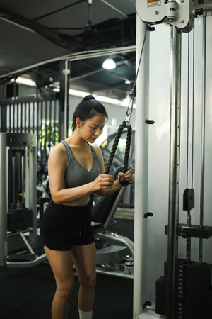 A Sporty Woman Performing Triceps Pushdown for Arm Strength.