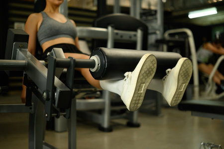 Close-up view of womanâ€™s legs performing leg extension workout on gym machine, Leg Day Focus.