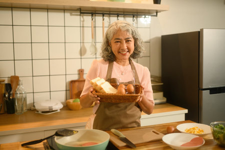 An Elderly Asian Woman Holding a Basket with Bread and Eggs in the Kitchen, Presenting Breakfast...