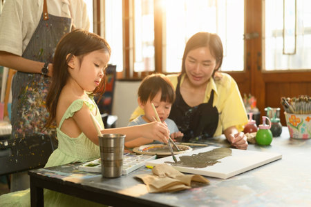 Young kids use paintbrushes to work on a shared art project, fostering creativity and motor skills...