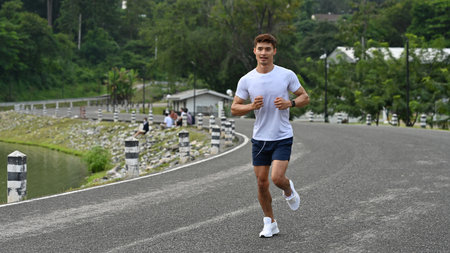 An Asian Male athlete running outdoors in sportswear, promoting health, energy, and cardio training.