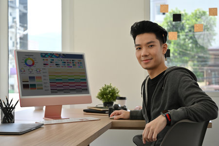 Portrait of a creative professional in casual attire, smiling at camera with a color palette...