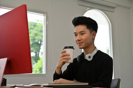 Confident designer focused on Red Desktop Computer, Creative Professional Working.