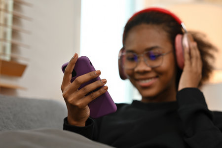 Close-up image of listening to Music on a Mobile, Selective focus on an African woman's hands...