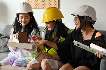 A portrait of three pretty Asian girls wearing a helmet, playing roles as architecture or engineering, for education, career and safety concept.の写真素材
