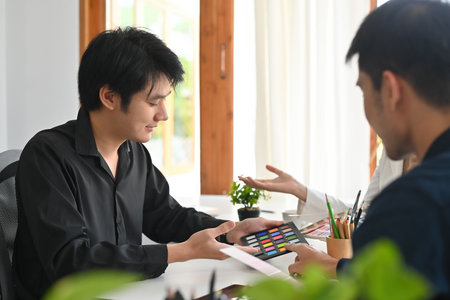 A portrait of Asian designers or a creative workers working together in the office choosing a color in the palettes, for art, design, technology and business concept.の写真素材