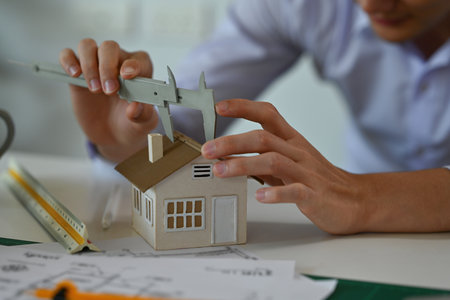 A portrait of an architecture working on a house model,  blueprint with tools and machine on the...