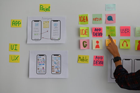 Pointing a female finger on a paper note about new creative technology design and mobile user...