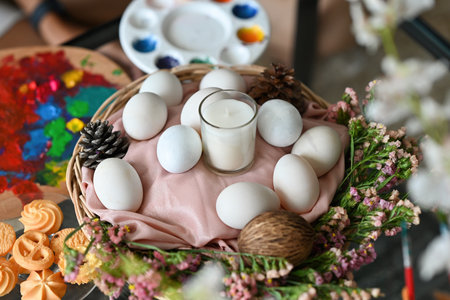 The close up of duck's eggs and scented candle in a wooden basket with Easter day decoration getting ready for special holiday.の写真素材