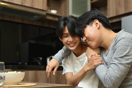 Gay couple hugging in their apartment, LGBT pride month and LGBT couple concept.の写真素材