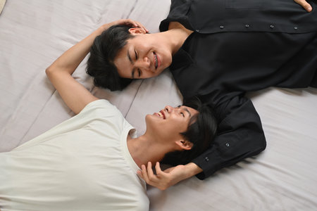 Top view with LGBT couple lying on the bed while hugging and embracing each other, LGBT Lifestyle...