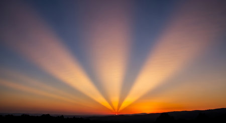Sunset in the mountains with rays of light on the horizon.