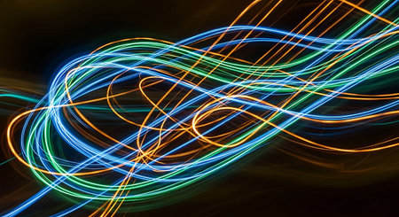 Abstract background with colorful light trails on dark backdrop. Long exposure.