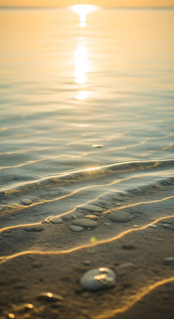 beautiful sunrise on the sea beach with sand and water ripplesの写真素材