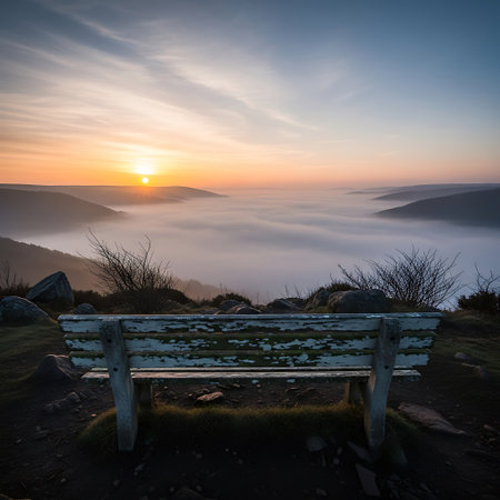 Sunrise over the foggy valley with a bench in the foregroundの写真素材