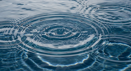 Water drop with ripples and waves on the surface of the waterの写真素材