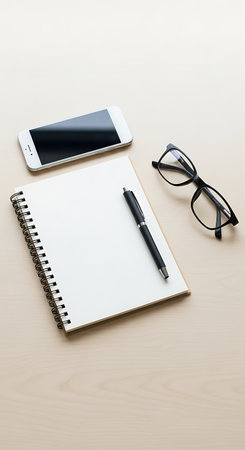 Office desk table with notepad, smartphone and eyeglasses.の写真素材