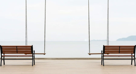 Wooden bench on the deck with sea and sky in background.の写真素材