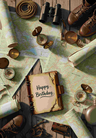 Top view of traveler's accessories, map, binoculars, boots, map and lettering Happy Birthday.