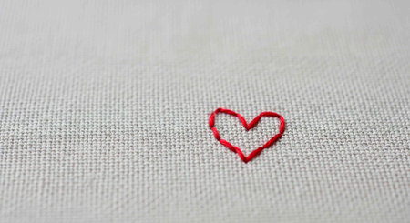 Red heart on white fabric background. Valentine's day concept. Copy space.