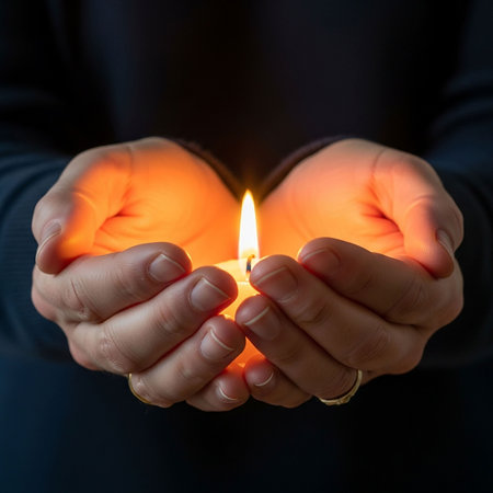 Burning candle in a man's hands on a dark background.の写真素材