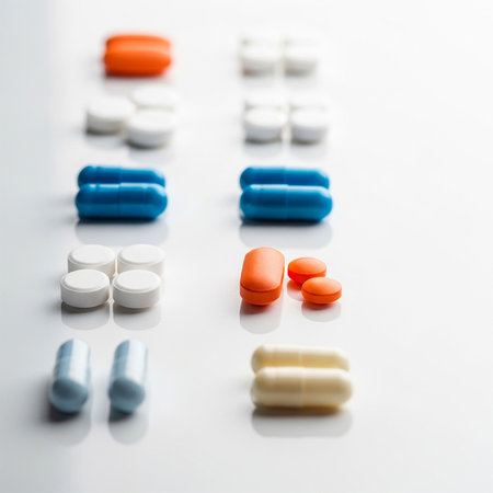 Tablets and capsules on white background. Focus on foreground, soft bokeh.