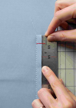 Tailor measures the fabric with a ruler, close-up