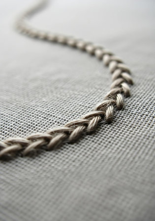 close up of braided rope on gray fabric background, shallow dof