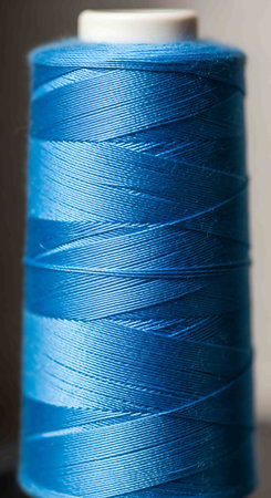 spool of blue thread close-up macro shot, shallow depth of field