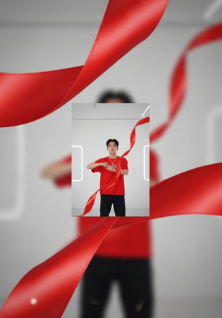 Young man and red ribbon on white background. Concept of winning.の写真素材