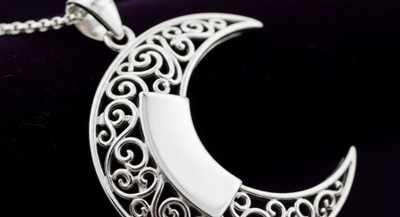 Silver pendant in the form of a crescent on a black backgroundの写真素材