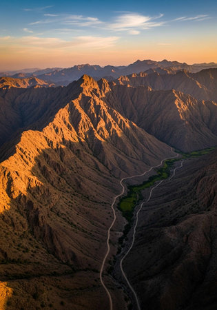 Aerial view of mountains and road at sunsetの写真素材
