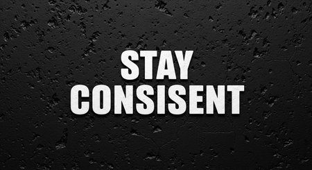 Stay CONSistent text on black textured wall. Business concept.の写真素材