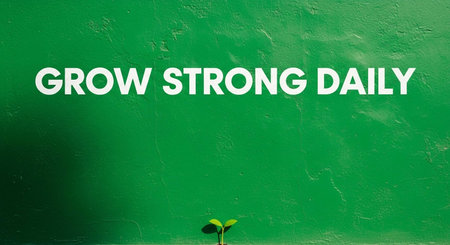 Grow Strong Day Sign on Green Wall with Small Plant Growing Outの写真素材