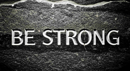 The word be strong written on a black stone. Toned.の写真素材