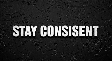 Stay Consistent text on black wall.の写真素材