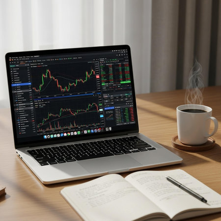 Laptop with stock market data on screen and coffee cup on wooden table