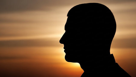 Silhouette of a man's head against a sunset background.の写真素材