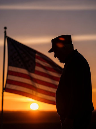 Silhouette of a man with an American flag at sunset.の写真素材