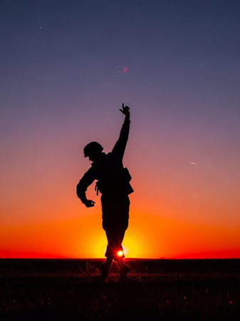 Silhouette of a man jumping on the field at sunset.の写真素材