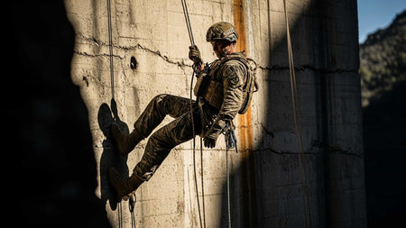 Man climbing on a wall in an abandoned building with ropes and ropesの写真素材