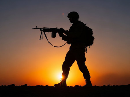 Silhouette of a soldier with a machine gun on sunset background