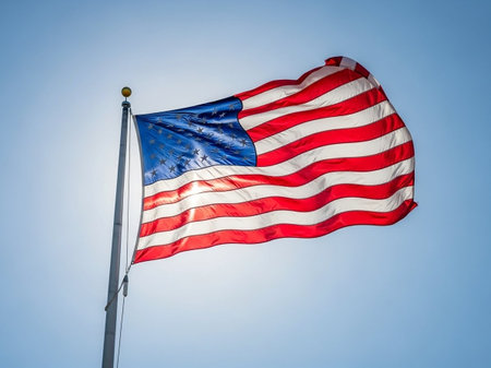 American flag waving in the wind against a blue sky with copy space