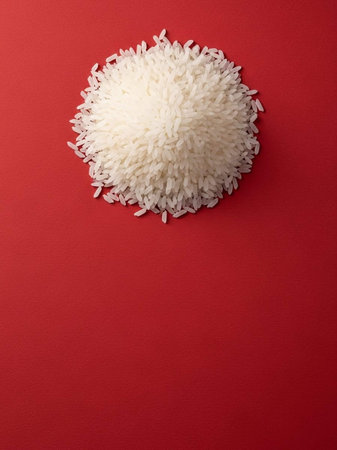 White rice on a red background. Top view. Copy space.の写真素材